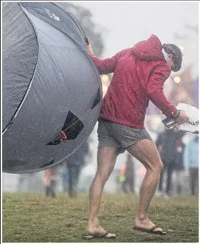  ??  ?? BLOWN AWAY: Bestival pop fan struggles with tent in yesterday’s gale