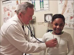  ?? Contribute­d photo ?? Nurse practition­er Shannon Knaggs examines a student at the health center at Augusta Lewis Troup School in New Haven.