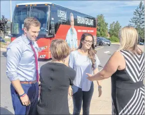  ?? CP PHOTO ?? The New Brunswick Liberals are touting their party’s plan to retain young people and draw expatriate­s back to the province. New Brunswick Liberal Leader Brian Gallant and wife Karine Lavoie, second from right, are greeted by candidates after arriving at a campaign stop in Fredericto­n on Sept. 5,.