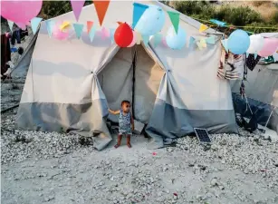 ??  ?? طفل سوري يقف أمام مخيم للنازحين في الالذقية أمس األول. (أ. ف. ب)