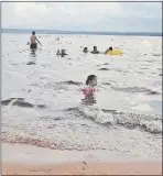  ??  ?? Pese a lo turbia que está el agua, adultos con sus familiares menores de edad ingresaban ayer al renombrado lago ahora verde.