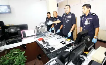  ??  ?? Ramli (second right) and Chandra (right) showing the stolen items recovered from the suspects, eight of whom have been arrested.