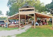  ?? [PHOTO PROVIDED] ?? A barn-style pavilion provides shade for shoppers and vendors at the Arcadia Farmers Market.