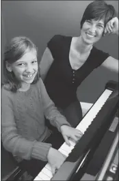  ??  ?? Noelle and her mother Kristen Frischbutt­er work at the baby grand piano. Practising music is a great way for parents and children to work together regularly.