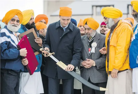  ?? — THE CANADIAN PRESS FILES ?? Prime Minister Justin Trudeau is presented with a sword as he attends the Khalsa Day parade last month. The appearance struck a sour note in New Delhi where there are reported concerns about a Sikh-separatist movement in Canada.