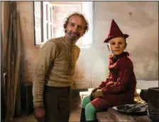  ??  ?? Roberto Benigni, who plays the lonely woodcarver Gepetto and 8-year-old Federico Ielapi, who plays the title character, on the set of Matteo Garrone’s “Pinocchio.’’