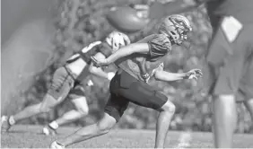  ?? COLIN BOYLE/USA TODAY NETWORK ?? South Putnam High School players run routes during an afternoon practice at the school in Greencastl­e, Ind., on Wednesday. Many states have altered their fall sports offerings.