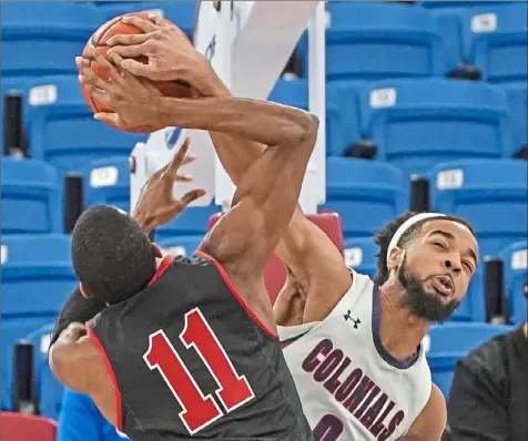  ?? Peter Diana/Post-Gazette ?? Robert Morris’ Josh Williams, right, blocks shot by Saint Francis’ Isaiah Blackmon Saturday at UPMC Events Center.