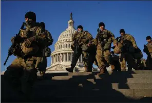  ?? (The New York Times/Erin Schaff) ?? National Guard troops patrol the perimeter of the U.S. Capitol on Wednesday. As defense officials beef up the security presence ahead of next week’s inaugural, police chiefs in major cities are being warned to be on high alert.