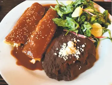  ?? Michael Bauer / The Chronicle ?? Chicken enchiladas con mole rojo ($20) had a complex sauce but were tepid on arrival.