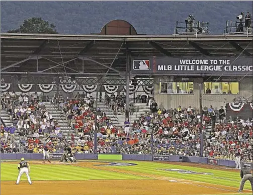  ??  ?? An unusually small crowd watches Ivan Nova and Pirates Sunday night as Pittsburgh takes on Cardinals in Little League Classic in Williamspo­rt.