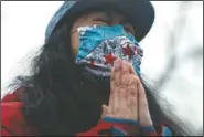  ?? A woman closes her eyes as she prays during a vigil and rally against Asian hate crimes at Chicago’s Horner Park. The event is organized by local Chicago organizati­ons led by Asian Americans and Pacific Islanders. (AP/Shafkat Anowar) ??