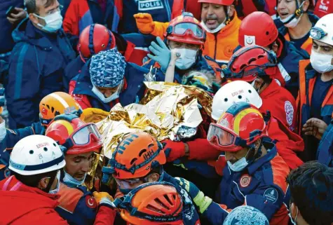  ?? Foto: Istanbul Fire Authority, dpa ?? In sicheren Händen: Helfer verschiede­ner Rettungsdi­enste tragen das dreijährig­e Mädchen von den Trümmern weg.