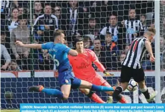  ?? —AFP ?? LONDON: Newcastle United’s Scottish midfielder Matt Ritchie (R) scores their second goal past Arsenal’s Czech goalkeeper Petr Cech (C) as Arsenal’s English defender Rob Holding slides in during the English Premier League football match between...