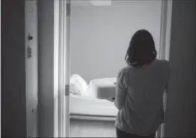  ?? CHRIS YOUNG, THE CANADIAN PRESS ?? A staff member carries bedding in one of the suites at Toronto’s Interval House, an emergency shelter for women in abusive situations.