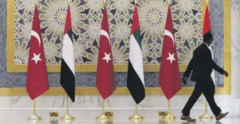  ?? ?? An official walks past Turkish and Emirati flags at Qasr Al-Watan in Abu Dhabi, UAE, Feb. 14, 2022.