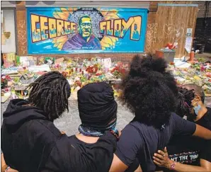  ?? Los Angeles Times ?? MOURNERS GATHER in front of Cup Foods, the Minneapoli­s market where George Floyd died at the hands of a police off icer in May, sparking protests and calls for reform.