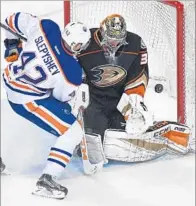  ??  ?? ANTON SLEPYSHEV of the Oilers takes a penalty for interferin­g with goalie John Gibson of the Ducks.