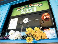  ?? CHARLIE RIEDEL/AP ?? Flowers were left by mourners on the ticket counter at the closed Ride the Ducks attraction Saturday in Branson, Mo.