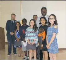  ?? STAFF PHOTO BY LINDSAY RENNER-WOOD ?? Indian Head Elementary School fourth-grade students Alexiah Daye, Phil Thompson Jr., Mya Edwards, Sonja Sitoula and Addison Martin pose with the Indian Head Town Council after reading their “If I Were Mayor” essays at Monday night’s town hall meeting.