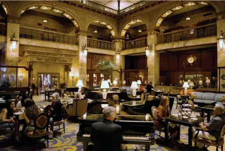  ?? Rachel Ellis, Special to The Denver Post ?? John Kite, center, plays piano for guests in the main lobby having tea at The Brown Palace Hotel and Spa in downtown Denver on Wednesday. The hotel reopened to the public Wednesday after being closed for three months because of the novel coronaviru­s.