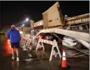  ?? TOM FOX — THE DALLAS MORNING NEWS VIA AP ?? The roof of the La Azteca grocery store peeled off and landed on vehicles parked outside as thundersto­rms rolled through Little Elm, Texas, on Thursday.