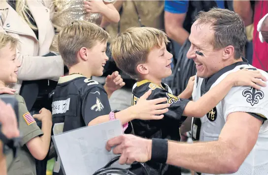  ?? AP ?? Saints quarterbac­k Drew Brees celebrates with his children after breaking the NFL all-time passing yards record.