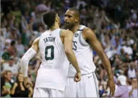  ?? THE ASSOCIATED PRESS ?? Boston Celtics forwards Jayson Tatum (0) and Al Horford, right, chest-bump to celebrate in the fourth quarter of Game 2 of the team’s NBA second-round playoff series against the Philadelph­ia 76ers, Thursday, May 3, 2018, in Boston.