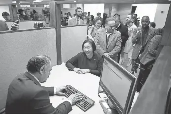  ?? FILE PHOTO BY JUSTIN SULLIVAN, GETTY IMAGES ?? Oakland Mayor Jean Quan, seated, registers for a municipal identifica­tion card on Feb. 1, 2013, after Oakland became the first city to offer such IDs to undocument­ed immigrants.