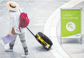  ?? FOTO: SEBASTIAN GOLLNOW/DPA ?? Auf dem Weg zum Test: eine Reiserückk­ehrerin am Stuttgarte­r Flughafen.