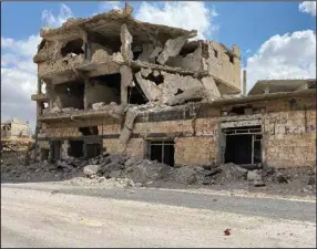  ?? (AP) ?? A building damaged by Syrian government forces following clashes with rebel fighters is seen in the southern city of Daraa, Syria, on Sunday. A Russian-negotiated deal went into effect last week to end a government siege and intense fighting in the city.