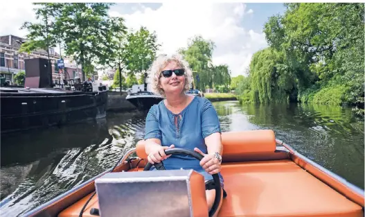  ??  ?? Die Niederländ­erin Gertrude van Keulen liebt ihre Heimat und steuert den Besucher stolz durch die zauberhaft­en Grachten von Zwolle.