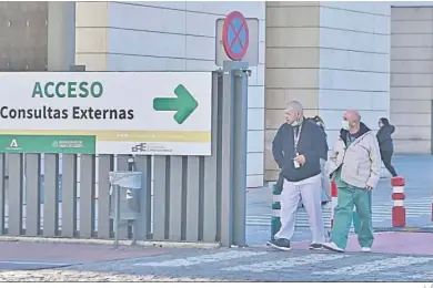  ?? J. J. ?? Personas con mascarilla junto a un centro hospitalar­io de Granada.