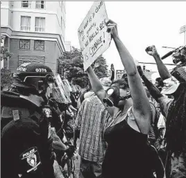  ?? DIEDRA LAIRD/CHARLOTTE (N.C.) OBSERVER ?? Protesters confront a line of police officers Sunday outside Bank of America Stadium before the Carolina Panthers-Minnesota Vikings football game in Charlotte, N.C.