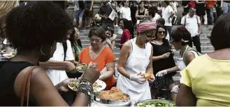  ?? Danilo Verpa/Folhapress ?? Manifestan­tes distribuem comida na frente do Theatro Municipal contra farinata de Doria