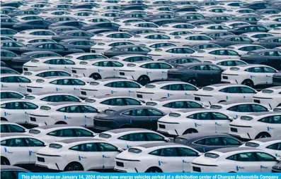  ?? — AFP ?? This photo taken on January 14, 2024 shows new energy vehicles parked at a distributi­on center of Changan Automobile Company in China’s southweste­rn Chongqing municipali­ty.