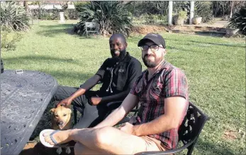  ?? PICTURE: DUNCAN GUY ?? CHEERS, BUDDY: Simphiwe Ngcobo pops in to wish his friend, Thommo Hart, all the best for his trip to climb seven peaks in seven weeks. The two men ran between Durban and Maputo last year in the footsteps of John Ross. Hart was barefoot.