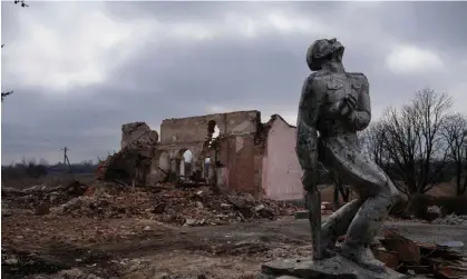  ?? Photograph: Alex Babenko/AP ?? A Soviet monument to the service personnel of the second world war stands in front of the ruins of a house near Avdiivka, a city the bombs played ‘a key role’ in destroying.