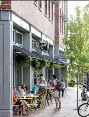  ?? NWA Democrat-Gazette/SPENCER TIREY ?? People sit enjoying the morning outside of Onyx Coffee Lab on June 8 in downtown Bentonvill­e.