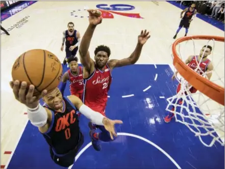  ?? CHRIS SZAGOLA — THE ASSOCIATED PRESS ?? Oklahoma City Thunder’s Russell Westbrook, left, goes up to shoot as Joel Embiid defends for the Sixers in the second overtime Friday.