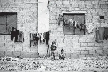  ?? Hassan Amar / Associated Press ?? Syrian children displaced from eastern Aleppo play Saturday in the village of Jibreen south of Aleppo, Syria. Aid agencies say that more than 30,000 people have fled rebel-held eastern neighborho­ods of Aleppo.