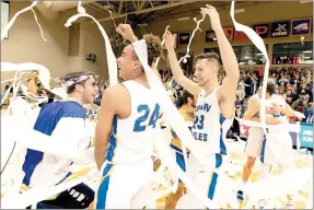  ?? Photo courtesy of John Brown University ?? John Brown basketball players, from left, Ira Perrier and Rokas Grabliausk­as celebrate as toilet paper flies to the floor during the annual Toilet Paper Game at Bill George Arena on Saturday.