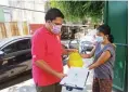  ??  ?? PARENTAL GUIDANCE A mother of a student at Longos National High School picking up the relief goods for her family