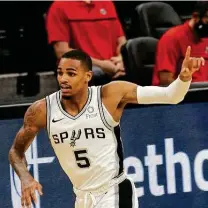  ?? Ronald Cortes / Contributo­r ?? Dejounte Murray acknowledg­es Spurs teammates after hitting a 3-pointer Sunday, part of the 11-point, 11-rebound, 10-assist triple-double he recorded despite playing on a sore ankle.