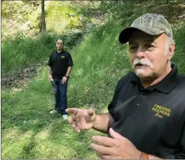  ?? MICHAEL RUBINKAM — THE ASSOCIATED PRESS ?? Dennis Parada, right, and his son Kem Parada stand at the site of the FBI's dig for Civil War-era gold in September 2018in Dents Run, Pa. A scientific analysis commission­ed by the FBI shortly before agents went digging for buried treasure suggested a huge quantity of gold was below the surface, newly released government documents say.