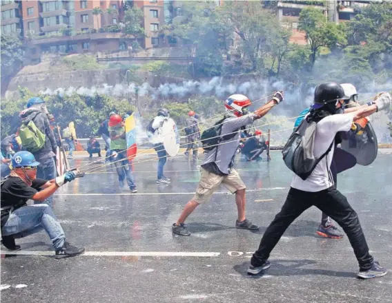  ??  ?? ► Manifestan­tes durante una protesta contra el gobierno de Maduro, en Caracas, en mayo pasado.