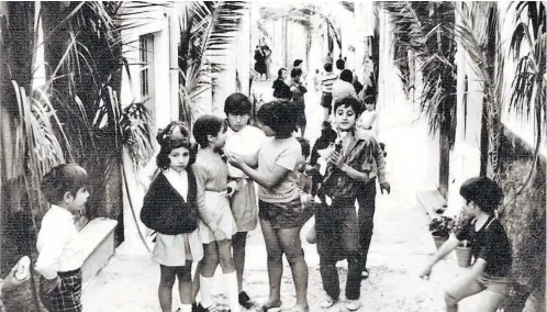  ?? ?? La calle Clarín de la Almedina fetejaba con ramas de palmera en las fachadas el día de la Inmaculada, allá por los años sesenta. En aquella época el 8 de diciembre había perdido fuerza patriótica y se celebraba con menos acento religioso.