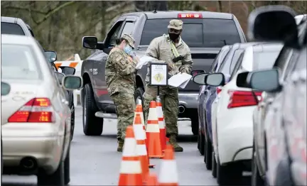  ?? AP PHOTO/MARK HUMPHREY, FILE ?? National Guard personnel check in people as they wait to receive a COVID-19vaccinat­ion Friday in Shelbyvill­e, Tenn. Tennessee has continued to divvy up vaccine doses based primarily on how many people live in each county, and not on how many residents belong to eligible groups within those counties.