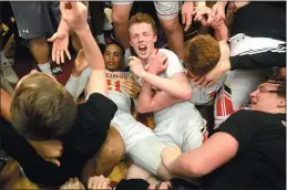 ?? PETE BANNAN — MEDIA NEWS GROUP ?? West Chester East players and fans mob a stunned Tym Richardson (21), left, after he hit a three-point shot with 1.8seconds left on the clock to give the Vikings a 38-35 victory over Pottsville Tuesday evening at Reading High School.