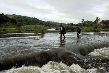  ?? ?? Pupils have to cross the Mtwalume River on their way home from school.